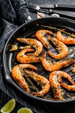 Izgara dev Langoustine karidesler, kızartma tavasında karidesler. Siyah arka plan. Üst görünüm.