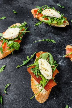 Peynirli sandviç, roka ve armut reçeli. Siyah arka plan. Üst görünüm.