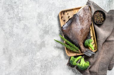 Biberiye ve brokoli ile ahşap tepside John Dory balığı. Gri arka plan. Üst Manzara. Boşluğu kopyala.