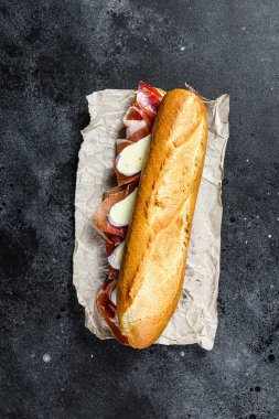 Jambonlu baget sandviç, Camembert peyniri. Siyah arkaplan, üst görünüm