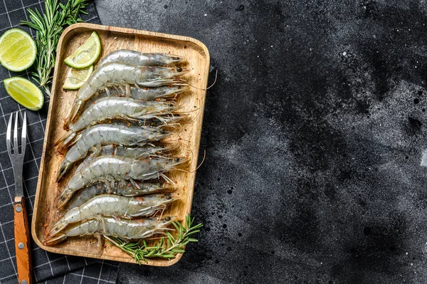 Taze çiğ langoustine karidesler, tahta tepside karidesler. Siyah arka plan. Üst Manzara. Boşluğu kopyala.