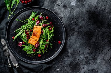 Alabalık, roka, marul ve kızılcıklı deniz ürünleri salatası. Siyah arka plan. Üst Manzara. Boşluğu kopyala.