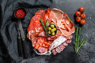 İspanyol soğuk et çeşitleri. Chorizo, fuet, LOMO, jamon Iberico, zeytin. Siyah arka plan. Üst görünüm