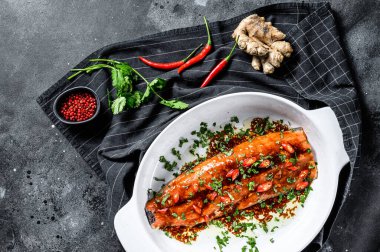 Teriyaki usulü alabalık pişiriyorum. Siyah arka plan. Üst görünüm.