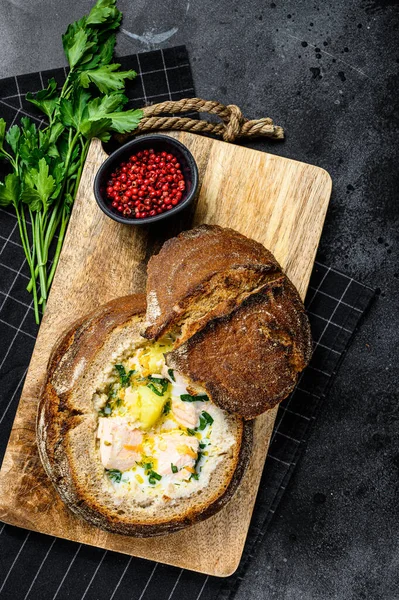 Salmon soup served in bread. Creamy hearty fish soup. healthy and diet food concept. Black background, top view — Stock Image Salmon Soup Served Bread Creamy Hearty Fish Soup Healthy Diet Stock Picture