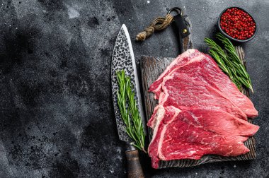 Çiğ taze et, baharatlı ve otlu biftek. Siyah arka plan. Üst Manzara. Boşluğu kopyala.