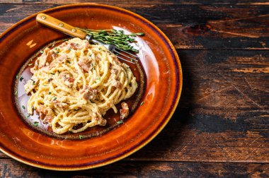 İtalyan spagetti Carbonara pastırmalı makarna, parmesan peyniri ve krem soslu. Karanlık ahşap arka plan. Üst Manzara. Boşluğu kopyala.