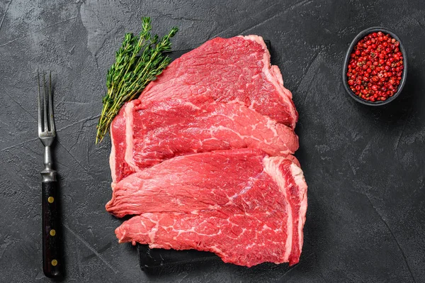 生の牛の肉は大理石の板の上にランプステーキを切る 黒の背景 トップ表示 — ストック写真
