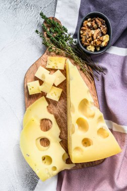 Delikli Maasdam peyniri, sütlü sarı üçgen. Gri arka plan. Üst görünüm.