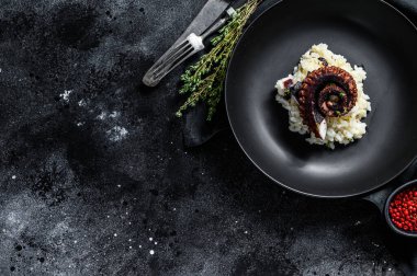 Ahtapot dokunaçlı bir parça Risotto. Siyah arka plan. Üst Manzara. Boşluğu kopyala.