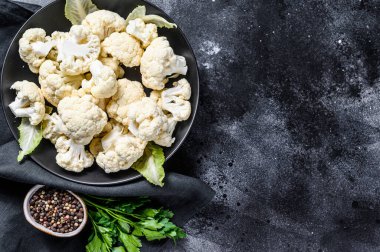 Taze beyaz kafalar karnabaharı bir kasede temizledi. Siyah arka plan. Üst Manzara. Boşluğu kopyala.