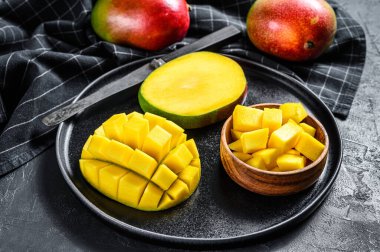 Olgun bir mango. Tropikal meyveleri küp küp doğra. Siyah arka plan. Üst görünüm.
