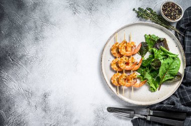 Kızarmış karides, karides ve ıspanak salatası. Gri arka plan. Üst Manzara. Boşluğu kopyala.