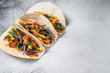 Biftek, soğan ve tatlı biberli Meksika tacoları. Beyaz arka plan. Üst Manzara. Boşluğu kopyala.