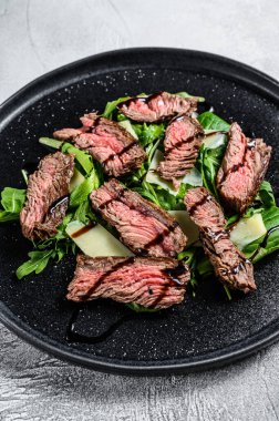 Ispanaklı biftek salatası, roka ve dilimlenmiş biftek. Gri arka plan. Üst görünüm.