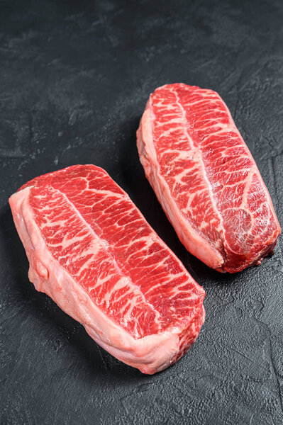 Raw organic meat Twagyu oyster top blade steak. Black background. Top view.