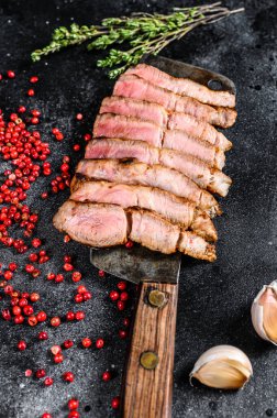 Baharat ve bitkilerle dilimlenmiş domuz pirzolası. Siyah arka plan. Üst görünüm