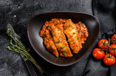 Domates soslu fırında halibut balığı. Siyah arka plan. Üst görünüm.