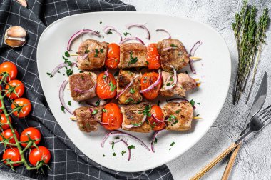 Tahta şişler üzerinde biftek ve domuz eti. Gri arka plan. Üst görünüm.