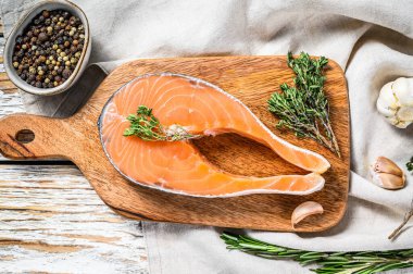 Doğrama tahtasında somon bifteği. Çiğ organik balık. Beyaz arka plan. Üst görünüm.