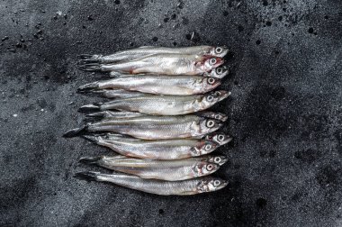 Taze çiğ deniz küçük balıklar kokar. Siyah arka plan. Üst görünüm.