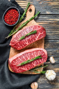 Çiğ mermer biftek, üst bıçak bifteği. Siyah arka plan. Üst görünüm.