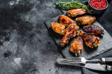 Soslu kızarmış tavuk kanadı. Siyah arka plan. Üst Manzara. Boşluğu kopyala.