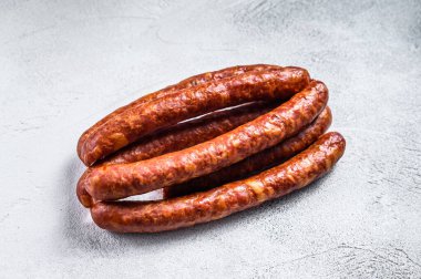 Kırsal bir masada sıcak füme sosis. Beyaz arka plan. Üst görünüm.