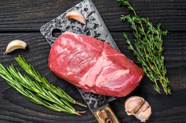 Satırda çiğ kuzu fileto biftek. Siyah ahşap arka plan. Üst görünüm.