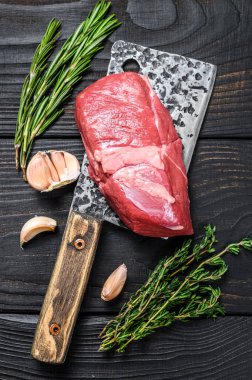 Satırda çiğ kuzu fileto biftek. Siyah ahşap arka plan. Üst görünüm.