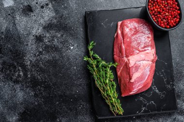 Taş bir tahtanın üzerinde çiğ kuzu eti eti. Siyah arka plan. Üst Manzara. Boşluğu kopyala.