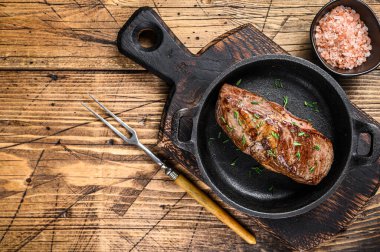 Tavada ızgara dana fileto biftek ve şifalı otlar. Ahşap arka plan. Üst Manzara. Boşluğu kopyala.