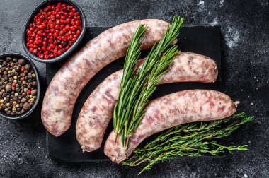 Çiğ domuz eti sosisleri ve otlar. Üst Manzara. Siyah arkaplan.