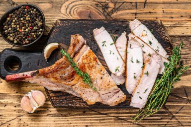 Dilimlenmiş pirzola, domuz pirzolası, biftek. Ahşap arka plan. Üst görünüm.