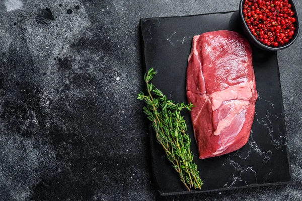 Taş bir tahtanın üzerinde çiğ kuzu eti eti. Siyah arka plan. Üst Manzara. Boşluğu kopyala.