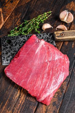 Çiğ etek, satırda mermer biftek. Karanlık ahşap arka plan. Üst görünüm.