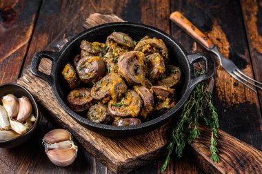 Pişmiş hindi kalbi ve şifalı otlar. Koyu ahşap arka plan. Üst görünüm.