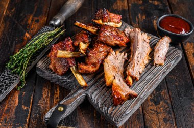 Kesme tahtasında ızgara ızgara dana pirzola. Koyu ahşap arka plan. Üst görünüm.