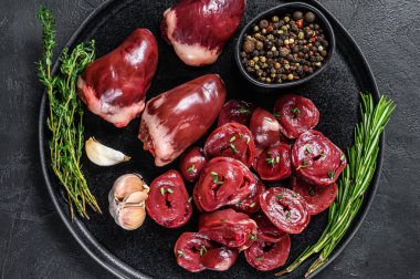 Dilimlenmiş çiğ hindi kalbi pişirmeye hazır. Siyah arka plan. Üst görünüm.