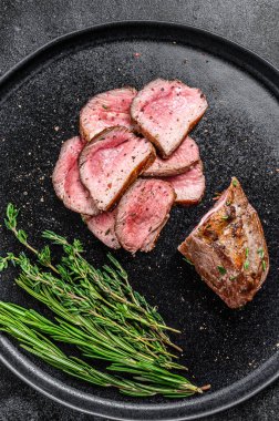 Barbekü ızgara kuzu fileto bifteği tabakta. Siyah arka plan. Üst görünüm.