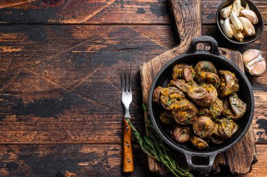 Pişmiş hindi kalbi ve şifalı otlar. Koyu ahşap arka plan. Üst Manzara. Boşluğu kopyala.