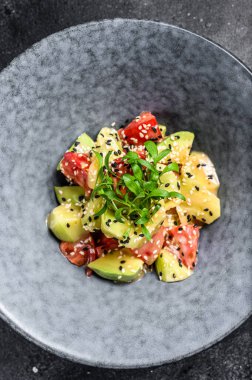 Diyet menüsü. Taze sebzeli sağlıklı salata, domates, avokado, roka, ıspanak. Siyah arka plan. Üst görünüm.