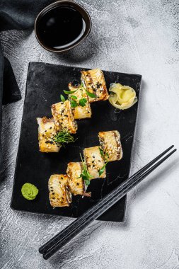 Suşi, Maki suşisi, füme yılan balığı ve salatalık. Gri arka plan. Üst görünüm.