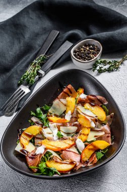 Prosciutto, şeftali ve roka ile salata. Soğuk atıştırmalıklar. Gri arka plan. Üst görünüm.