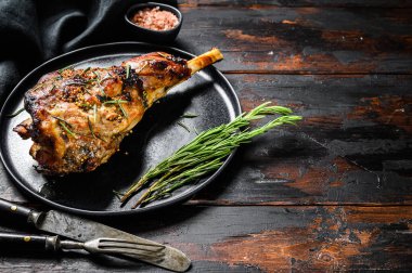 Kızarmış keçi budu. Çiftlik eti. Karanlık ahşap arka plan. Üst Manzara. Boşluğu kopyala.