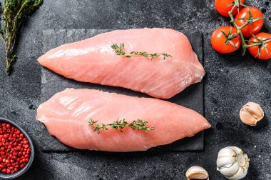 Çiğ hindi bifteği. Göğüs filetosu. Siyah arka plan. Üst görünüm