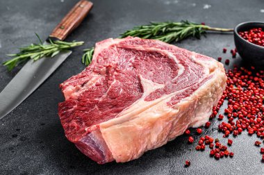 Kemiğe pirzola ya da kovboy bifteği. Çiğ mermer biftek. Siyah arka plan. Üst görünüm.