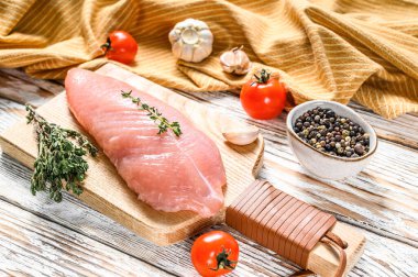 Kesme tahtasında çiğ hindi göğsü. Biftek. Beyaz ahşap arka plan. Üst görünüm.