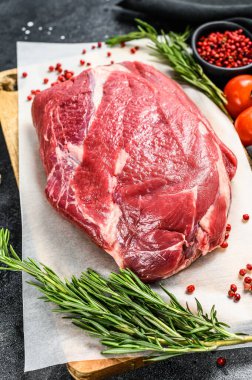 Tahta bir kesme tahtasının üzerinde çiğ et kesimi. Siyah Angus bifteği. Siyah arka plan. Üst görünüm.