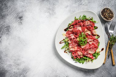 İtalyan etli carpaccio roka salatası, parmesan peyniri. Gri arka plan. Üst Manzara. Boşluğu kopyala.